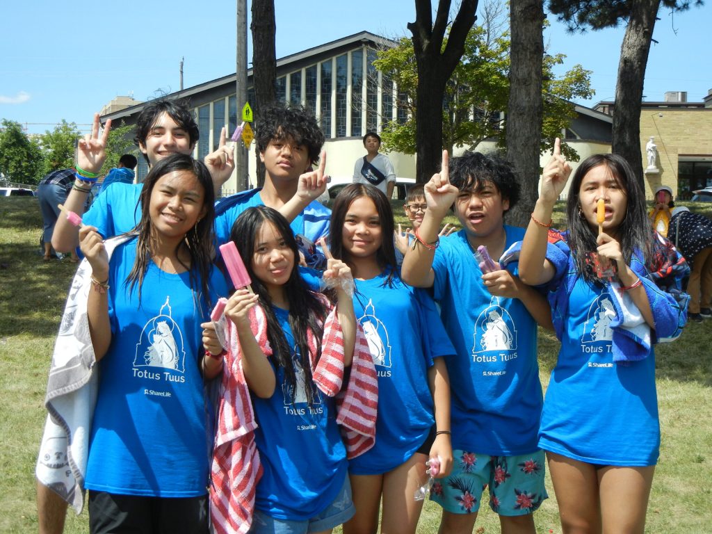 Youth ministry group in matching blue shirts outdoors on a summer day